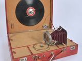 a red suitcase with a record in it on a white surface