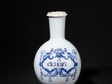 a blue and white vase sitting on a black surface