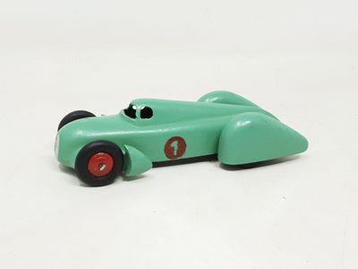 a green toy car that is sitting on a white surface