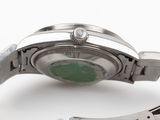 a close up of a watch with a green face