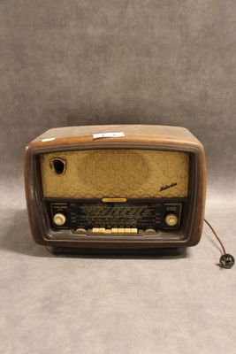 une radio à l'ancienne posée sur une table près d'un mur gris