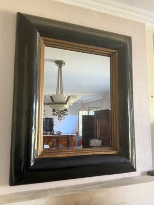 a mirror hanging on the wall above a fireplace
