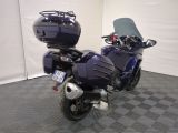 a blue motorcycle parked in a room with a checkered floor