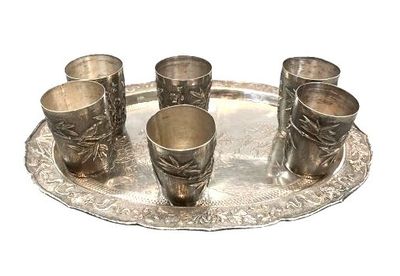 quatre coupes en argent posées sur un plateau en argent, sur fond blanc