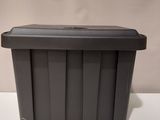 a close up of a black plastic container on a white surface