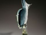 a glass bird sitting on top of a glass vase