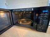 a black microwave with a glass door on the counter