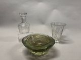 un saladier en verre et une bouteille en verre posés sur une table