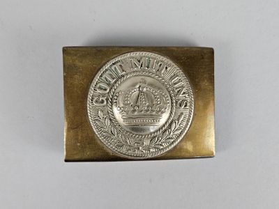 un gros plan d'une boucle de ceinture en métal ornée d'une couronne