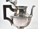 a silver teapot with a wooden handle on a white background