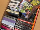 a cardboard box full of various movies and dvds