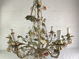 a chandelier with flowers and leaves hanging from it