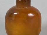 a brown glass bottle with a brown lid on a table