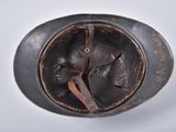 an old helmet with a leather band on a white surface