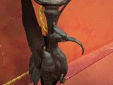 un bougeoir en bronze surmonté d'un oiseau