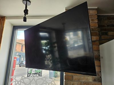 un téléviseur à écran plat suspendu au plafond dans une pièce