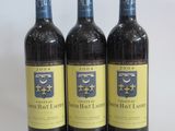 three bottles of wine sitting on top of a table next to each other