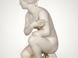 an image of a statue of a woman kneeling on a marble base