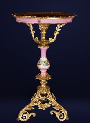 an ornately decorated table with a pink and gold base