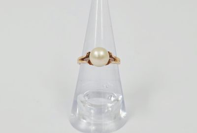 Gros plan sur une bague en or ornée d'une perle