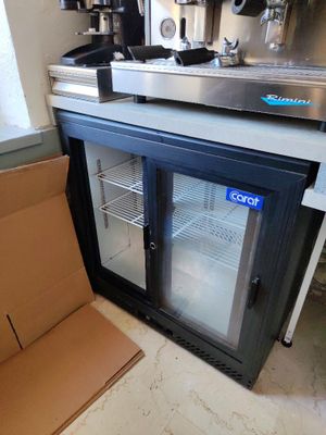 une machine à café posée à côté d'un carton posé par terre
