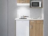 une petite cuisine équipée d'un micro-ondes et d'un lave-vaisselle