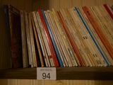 une étagère remplie de livres sur lesquels est apposée une étiquette de prix