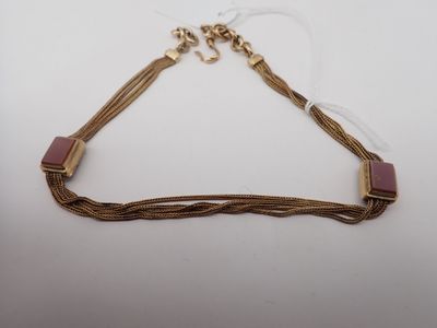 a gold and pink necklace on a white background