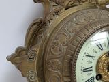 a gold clock with roman numerals on the face of it