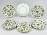 six plates and a bowl with floral designs on them on a white surface