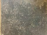 un vieux livre posé sur une table en bois à côté d'un mur