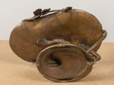 a bronze vase with a bird on it on a table