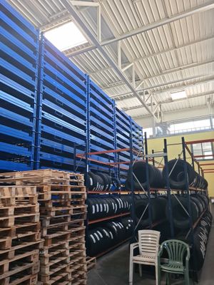 a large amount of pallets and chairs in a warehouse