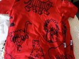 red t - shirt with black animals on it on a bed