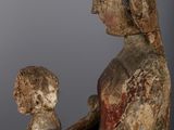 an old wooden statue of a woman holding a child