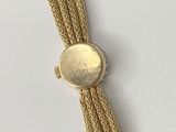 a close up of a gold bracelet on a white surface
