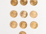 several gold coins arranged in a triangle on a white surface