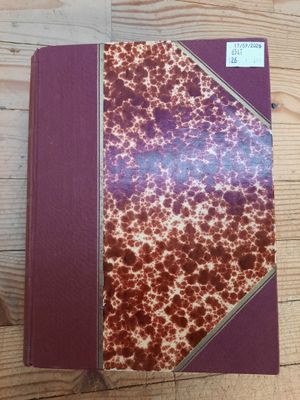 un livre rouge et blanc posé sur une table en bois