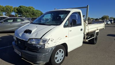 a white truck that has been damaged and is parked in a lot
