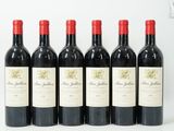 six bouteilles de vin rouge sont alignées sur une surface blanche