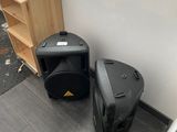 two speakers sitting next to each other on the floor