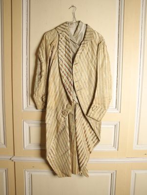 un peignoir rayé beige accroché au mur à côté d'une porte