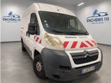 La camionnette blanche est garée dans une grande pièce décorée de rayures rouges et blanches.