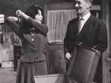 black and white photograph of a man and a woman opening a suitcase