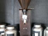 a picture of a coffee grinder on a shelf in a coffee shop