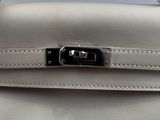 a close up of a white leather handbag with a metal clasp