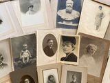 several old photographs of people are arranged on a bed