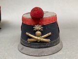 two small hats with a red ball on top of them