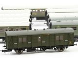 many green trains that are lined up together on the tracks