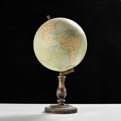 a small globe that is on a stand on a table